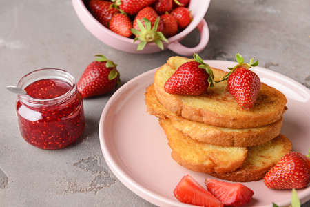 Plate with tasty French toasts and strawberry on gray backgroundの写真素材