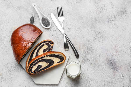Tasty cut poppy bun on gray background