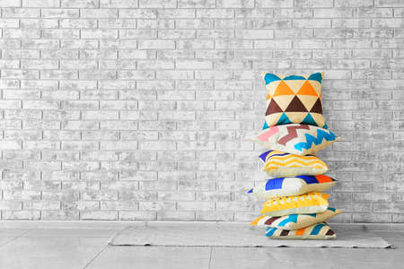 Soft pillows on floor near brick wallの写真素材
