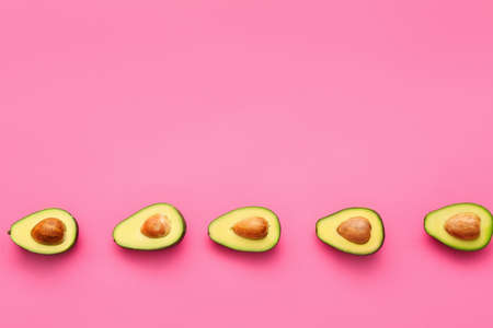 Halves of fresh avocados on color backgroundの写真素材