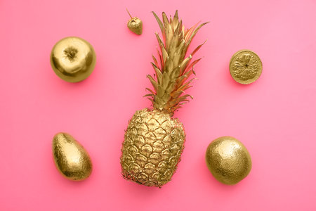 Golden tropical fruits on color backgroundの写真素材