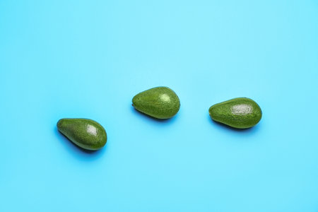 Fresh avocados on color background