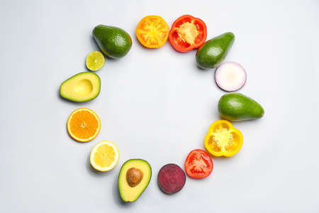 Frame made of avocado, fruits and vegetables on light background