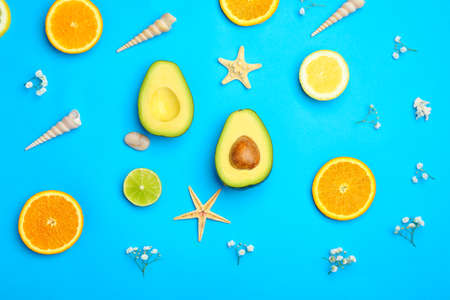 Fresh avocado, citrus fruits and sea shells on color backgroundの写真素材
