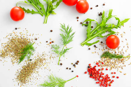 Fresh herbs with spices and tomatoes on light backgroundの写真素材