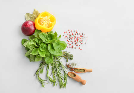 Fresh herbs with vegetables and spices on light backgroundの写真素材