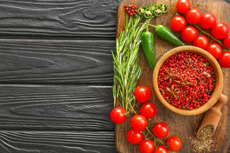 Board with spices, fresh vegetables and rosemary on dark wooden tableの写真素材