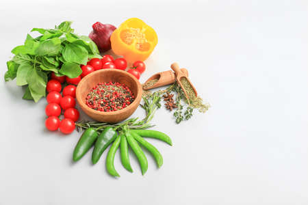 Fresh herbs with vegetables and spices on light backgroundの写真素材