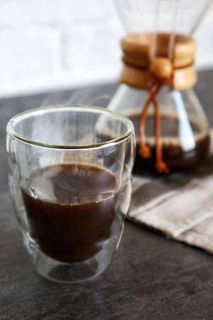 Glass of hot coffee on table