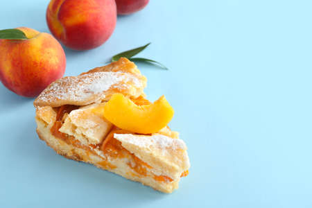 Piece of tasty peach pie on color backgroundの写真素材