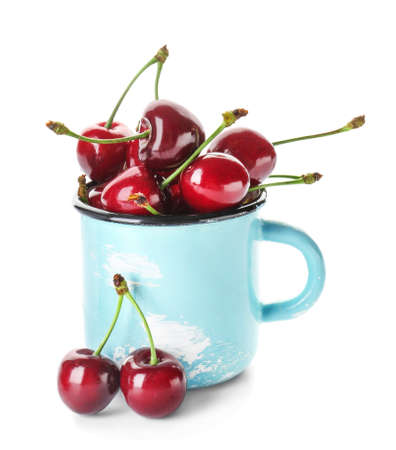 Mug with sweet ripe cherry on white backgroundの写真素材