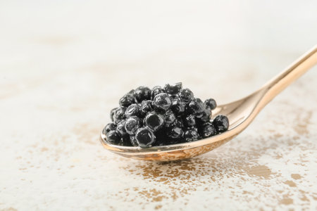 Spoon with black caviar on white backgroundの写真素材