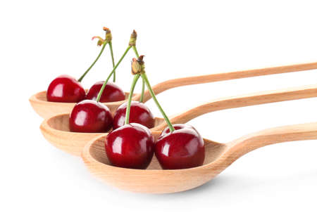 Spoons with sweet ripe cherry on white backgroundの写真素材