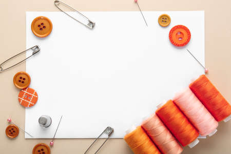 Set of sewing threads with accessories and sheet of paper on color backgroundの写真素材