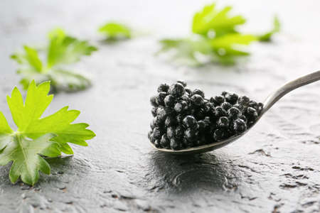 Spoon with delicious black caviar on dark backgroundの写真素材