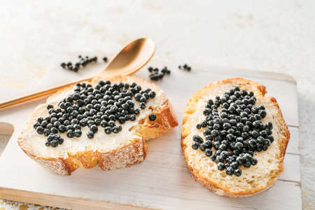 Sandwiches with black caviar on board