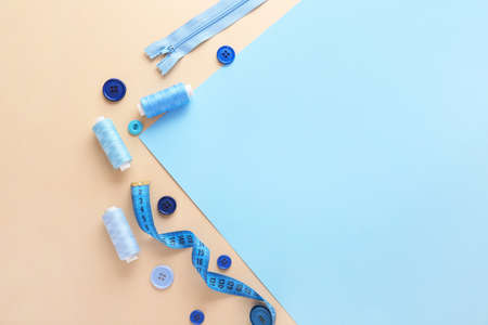 Set of sewing threads and accessories on color background