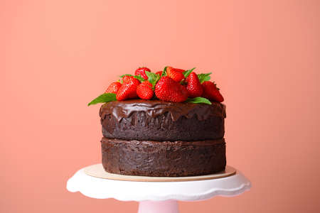 Tasty chocolate cake with strawberry on color background