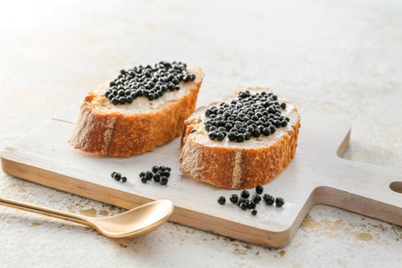 Sandwiches with black caviar on boardの写真素材