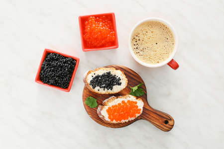 Sandwiches with delicious caviar with coffee on light tableの写真素材