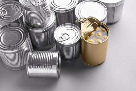Tin cans with food on gray background