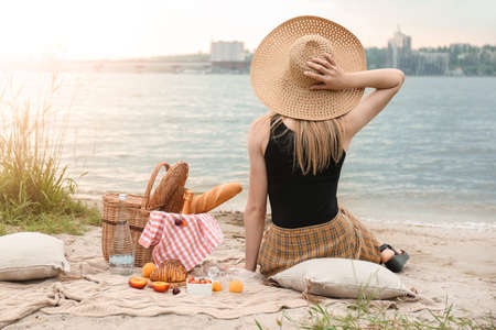 Young woman on picnic near riverの写真素材