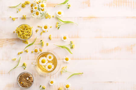 Composition with hot chamomile tea on light wooden tableの写真素材