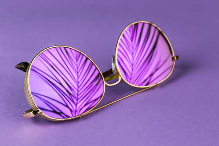 Modern sunglasses on color background