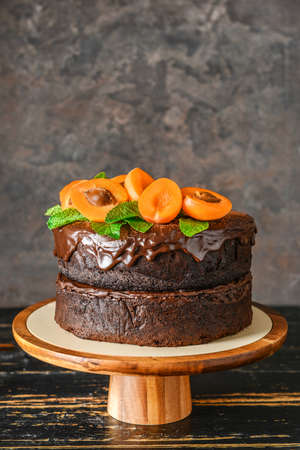 Stand with tasty chocolate cake on wooden tableの写真素材