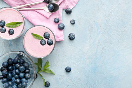 Glasses with tasty blueberry smoothie on color backgroundの写真素材