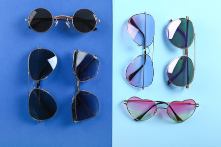 Different modern sunglasses on color backgroundの写真素材