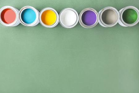Cans of paints on color background