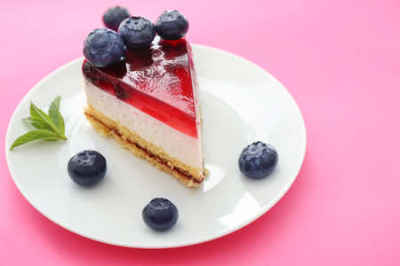 Piece of tasty blueberry cheesecake on color background