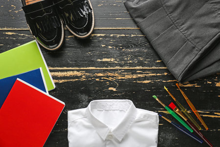 School uniform and stationery on wooden backgroundの写真素材