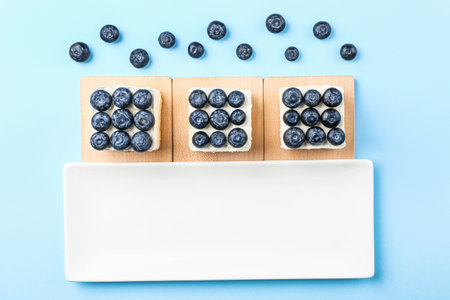 Tasty blueberry cakes on color backgroundの写真素材