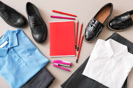 School uniform and stationery on gray background