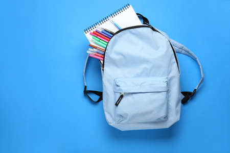 School backpack with stationery on color backgroundの写真素材
