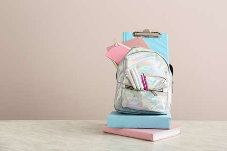 School backpack with stationery on table against light backgroundの写真素材