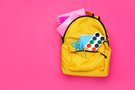 School backpack with stationery on color backgroundの写真素材