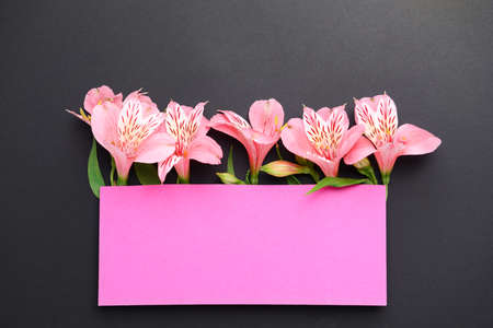 Empty greeting card with beautiful flowers on dark backgroundの写真素材