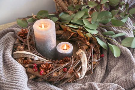 Decorative wreath, burning candles and eucalyptus branches on tableの写真素材