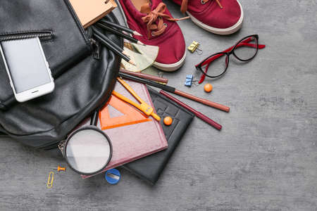 Different school stationery, shoes and backpack on gray background