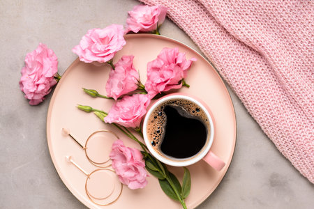 Composition with beautiful fresh flowers and cup of coffee on gray backgroundの写真素材