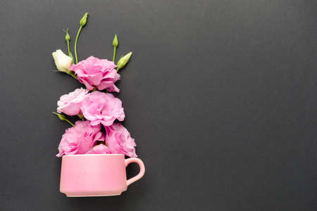 Cup with beautiful fresh flowers on dark backgroundの写真素材