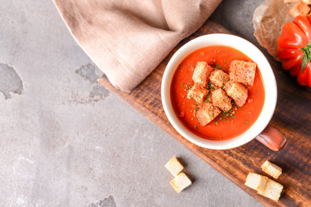 Cup of tasty tomato cream soup on grunge backgroundの写真素材