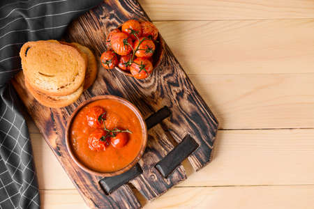 Bowl of tasty tomato cream soup on wooden tableの写真素材