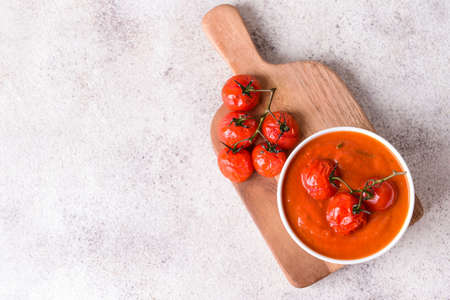 Bowl of tasty tomato cream soup on gray backgroundの写真素材