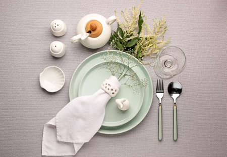 Beautiful table setting with floral decor on gray background