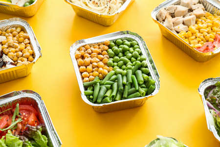 Many containers with delicious food on color backgroundの写真素材