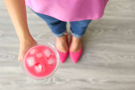 Woman with glass of tasty summer cocktail indoors, closeupの写真素材
